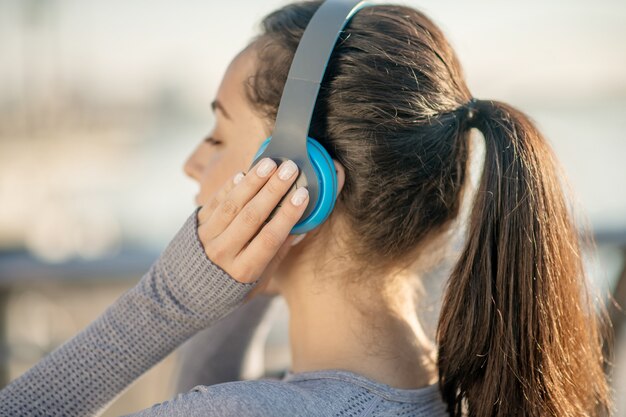 Écouter de la musique. Gros plan d'une tête de filles dans les écouteurs