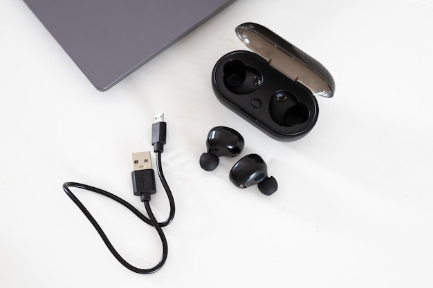 Écouteurs Bluetooth utilisés comme outil sans fil pour écouter de la musique et passer des appels téléphoniques avec un boîtier et un câble de charge