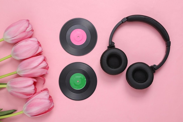 Écouteurs et disques vinyles avec bouquet de tulipes roses sur fond rose Fête de la musique Vue de dessus