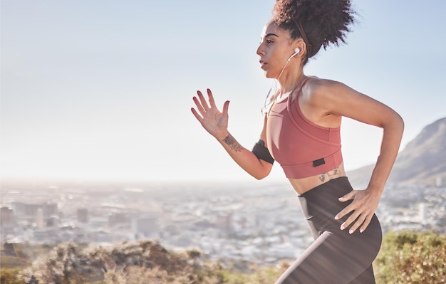 Écouteurs de fitness et femme courant dans la nature pour la santé, le bien-être et l'exercice tout en écoutant de la musique Sports de motivation et fille faisant de l'entraînement en plein air pour une course ou une compétition de marathon