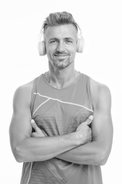 Écoutez de la musique pour vous motiver Entraînez-vous à l'aise avec votre liste de morceaux préférés Casque sans fil pour le sport Concept de casque moderne Homme beau sportif mal rasé écoutant de la musique gadget