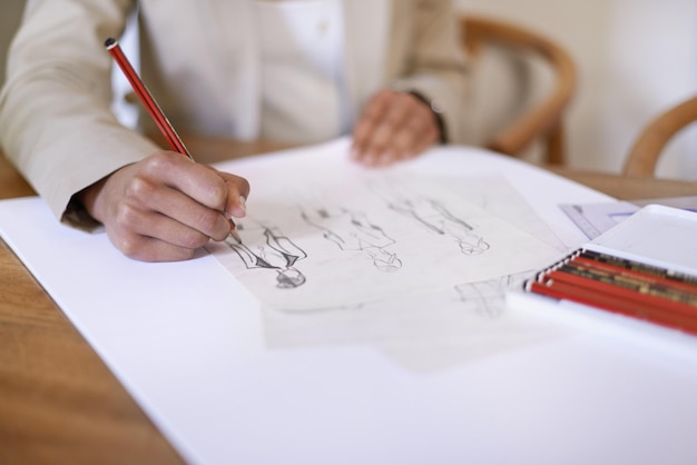 Photo couturier mains ou dessin sur papier avec un crayon dans le bureau de démarrage d'une petite entreprise vue rapprochée créative ou dessinateur de mode croquis au bureau pour la planification d'illustration de projet ou l'écriture d'un brouillon de vêtements