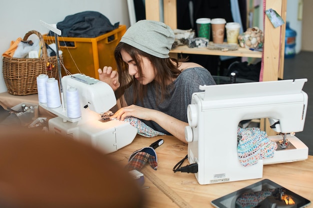 La Couturière Le Cou Coud Des Vêtements Dans Le Studio