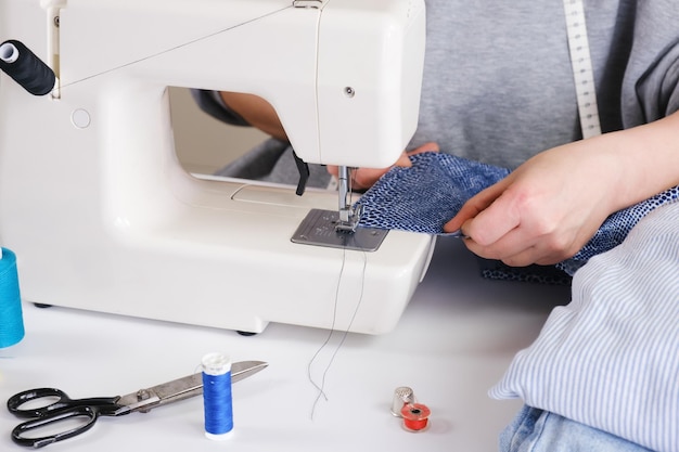 Couturière fait une couture sur une machine à coudre électrique