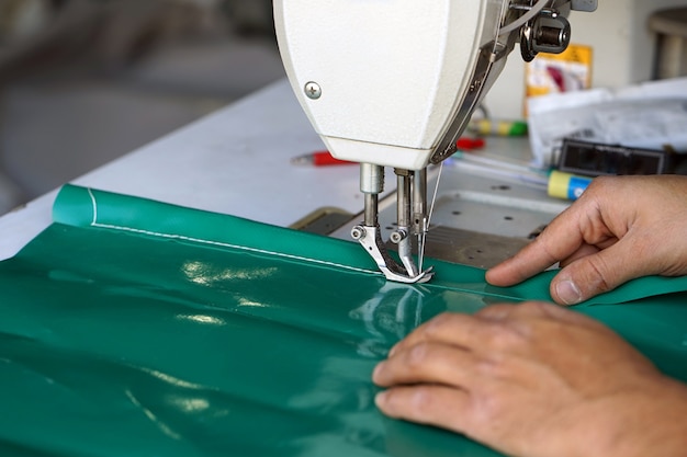 Couturière homme. Les mains des hommes derrière le cuir à coudre.