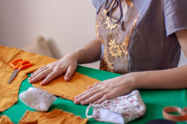 La couturière lisse l'ébauche de tissu pour le masque