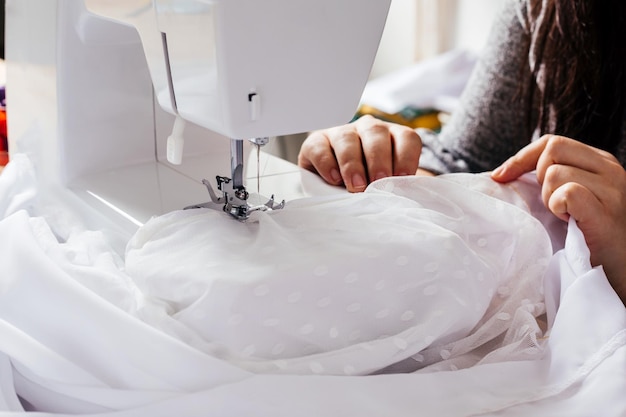 Couturière de mariage modifiant la robe de mariée vintage blanche