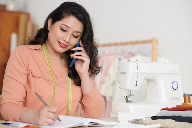 Couturière positive parlant au téléphone