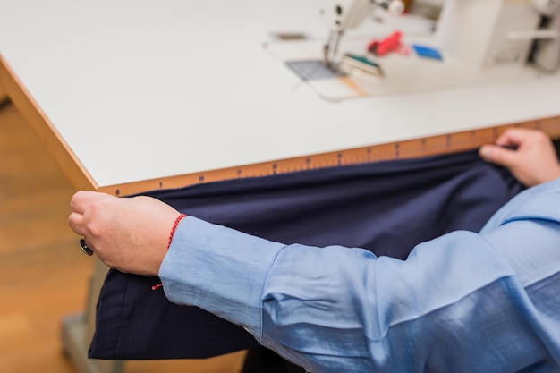 Couturière ruban à mesurer travaillant sur le tissu de l'industrie textile close up personne méconnaissable