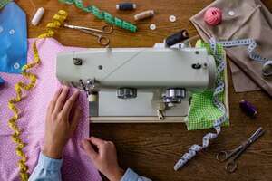 Photo couturière utilisant une machine à coudre et divers accessoires de couture pour la production de vêtements