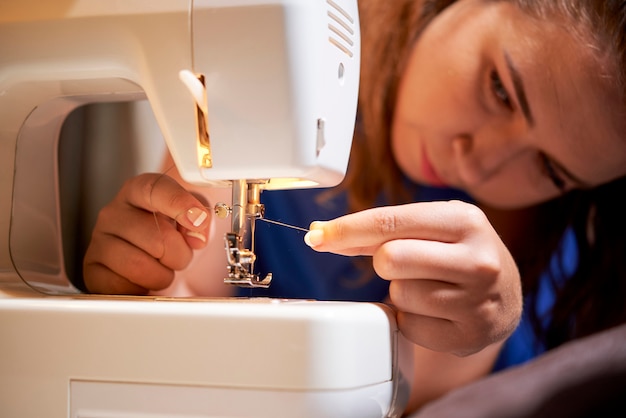 La couturière va coudre sur la machine à coudre