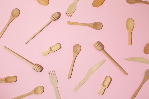 Des couverts de cuisine en bois sur un fond rose