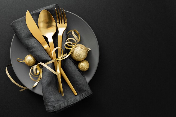 Couverts en or servis sur une assiette pour le dîner de Noël