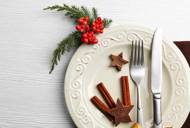 Couverts de service de Noël sur une assiette sur une table en bois clair, gros plan