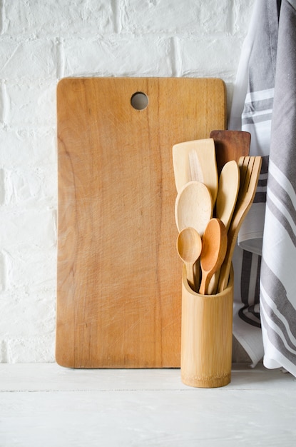 Couverts, serviettes et planches à découper en bois ou en bambou à l&#39;intérieur d&#39;une cuisine blanche.