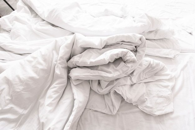 Couverture et drap froissés sur le lit le matin