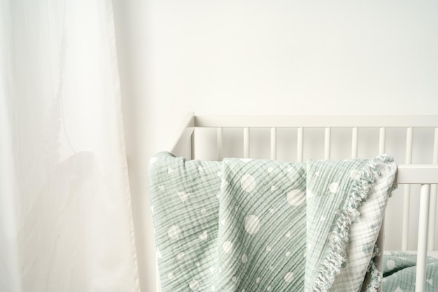 Une couverture en mousseline suspendue sur le lit de l'enfant dans la chambre d'infirmière