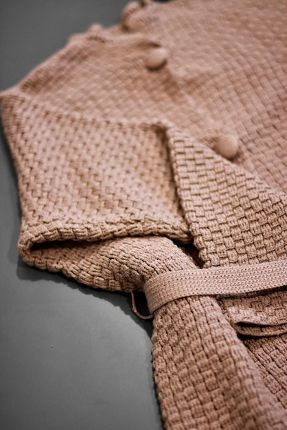 Une couverture en tricot marron avec un bouton marron.