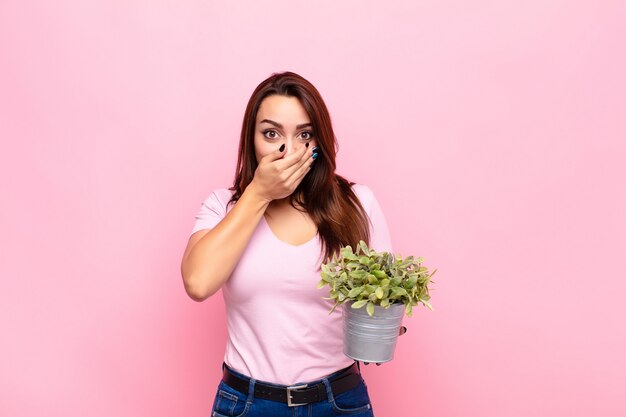 couvrant la bouche avec les mains avec une expression choquée et surprise, en gardant un secret ou en disant oups