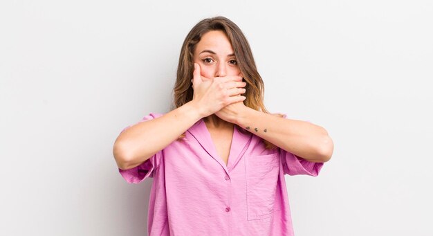 couvrant la bouche avec les mains avec une expression de surprise choquée en gardant un secret ou en disant oups