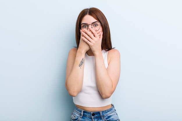 couvrant la bouche avec les mains avec une expression de surprise choquée en gardant un secret ou en disant oups