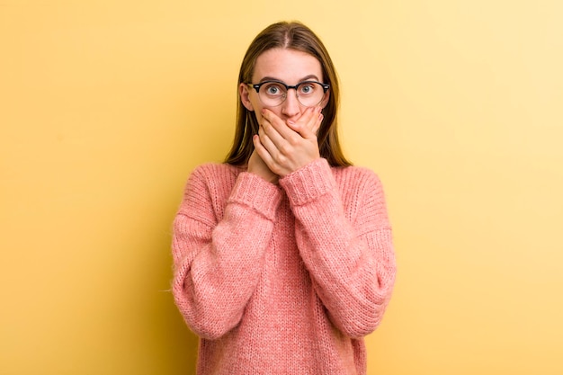 couvrant la bouche avec les mains avec une expression de surprise choquée en gardant un secret ou en disant oups