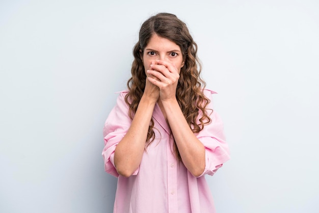 couvrant la bouche avec les mains avec une expression de surprise choquée en gardant un secret ou en disant oups