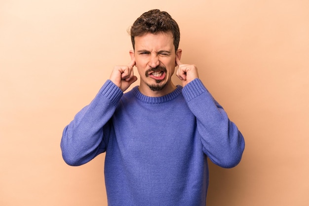 Couvrant les oreilles avec les doigts stressés et désespérés par une ambiance bruyante