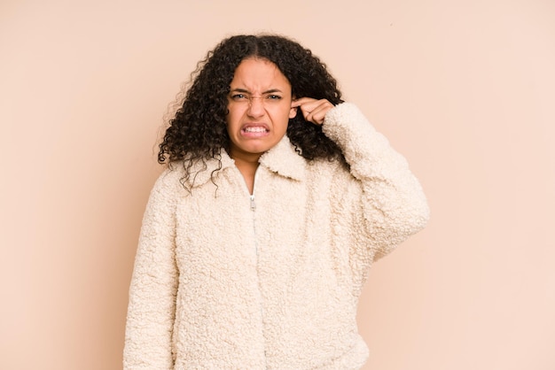 Couvrant les oreilles avec les doigts stressés et désespérés par une ambiance bruyante