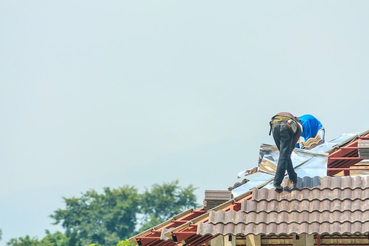 Photo couvreur de construction installant des tuiles de toit au chantier de construction de maison