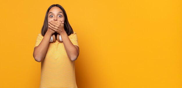 couvrir la bouche avec les mains avec une expression choquée et surprise, garder un secret ou dire oups