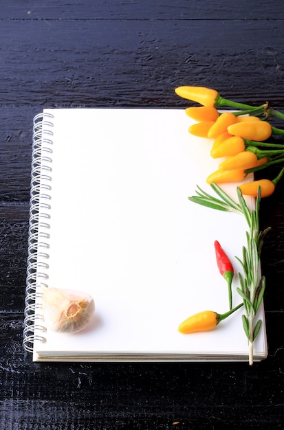 Couvrir le livre de cuisine sur une épices de table en bois noir recette de poivre au thym à l'ail