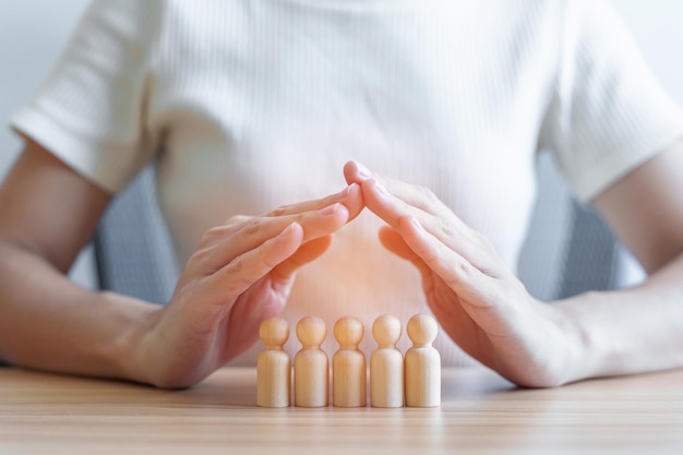 Couvrir à la main les hommes en bois de la foule des employés Les gens d'affaires La gestion des ressources humaines L'assurance-vie Le travail d'équipe et les concepts de leadership