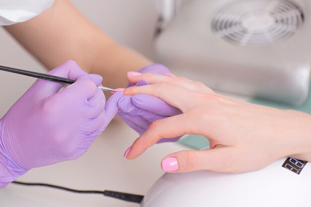 Couvrir les ongles avec du vernis à ongles rose