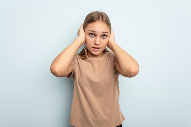 Couvrir les oreilles avec les mains en essayant de ne pas entendre un son trop fort