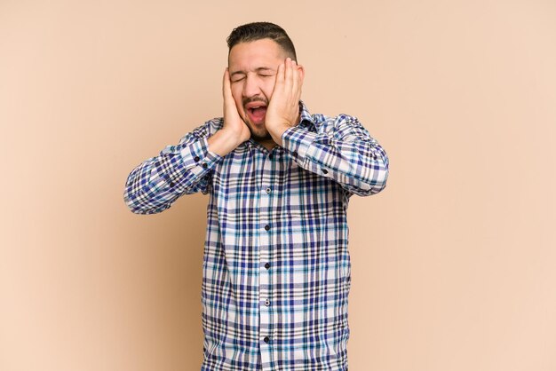 Couvrir les oreilles avec les mains en essayant de ne pas entendre un son trop fort