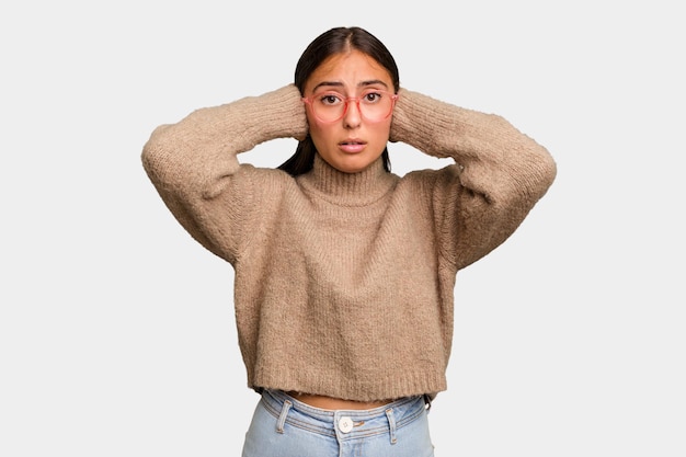 Couvrir les oreilles avec les mains en essayant de ne pas entendre un son trop fort