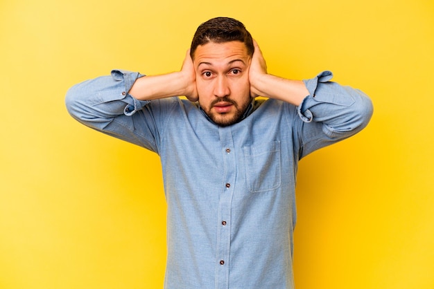 Couvrir les oreilles avec les mains en essayant de ne pas entendre un son trop fort