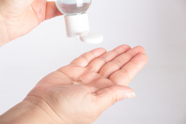 COVID-19 Close up woman hands using wash hand sanitizer gel dispenser, against Novel coronavirus (2019-nCoV)