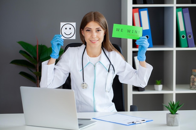 Photo covid 19 femme médecin tient un formulaire avec le texte que nous gagnons