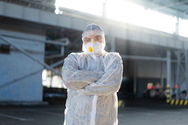 COVID19 coronavirus médecin debout hôpital parking vêtu d'une combinaison de protection blanche combinaison de matières dangereuses