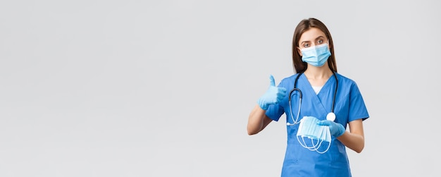 Covid19 empêchant les travailleurs de la santé des virus et le concept de quarantaine Une infirmière professionnelle ou un médecin en gommage bleu et équipement de protection individuelle recommandent d'utiliser des masques médicaux
