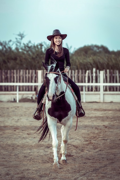 Photo la cow-girl asiatique à cheval.