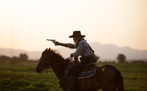 Cowboy à cheval contre un beau coucher de soleil