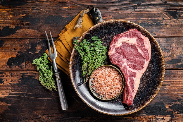 Cowboy cru ou bifteck de faux-filet Viande de bœuf vieillie à sec Fond en bois Vue de dessus