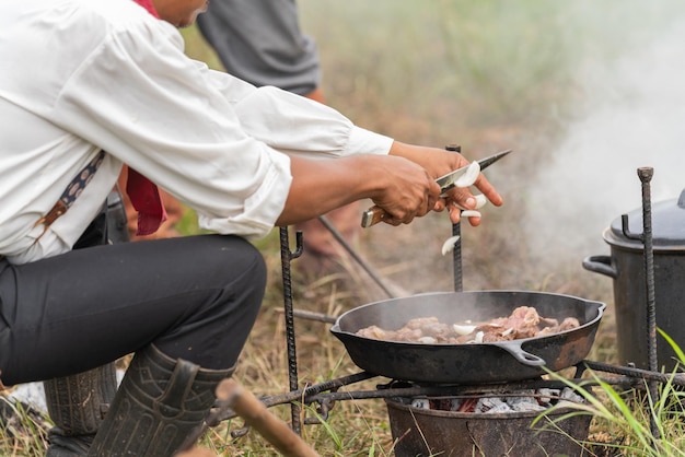 Cowboy cuisinant des aliments au camping