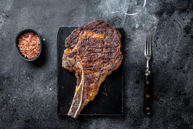 Cowboy grillé ou faux-filet avec steak de bœuf osseux Fond noir Vue de dessus