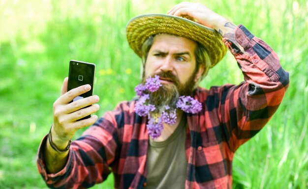 Cowboy hipster sur le terrain avec smartphone Réseaux sociaux Appel vidéo Internet disponible dans la plupart des coins reculés du pays Communication en ligne Internet et communication abordables de haute qualité