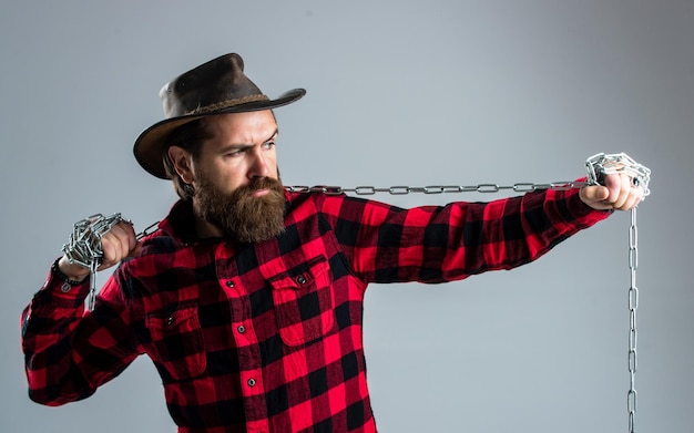 Cowboy homme avec barbe et moustache tirer la routine de la chaîne en acier au ranch