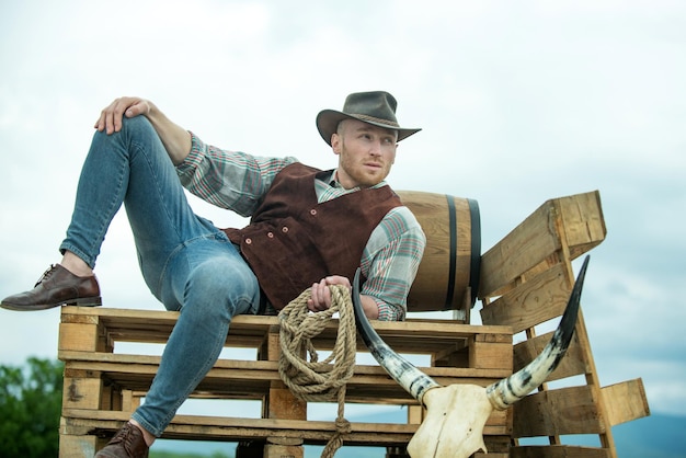 Cowboy sur ranch Bel homme au chapeau de cowboy et tenue vintage rétro Hommes mode rétro vintage vogue modèle masculin brutal